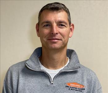smiling man in gray pullover with SERVPRO logo on the breast pocket area